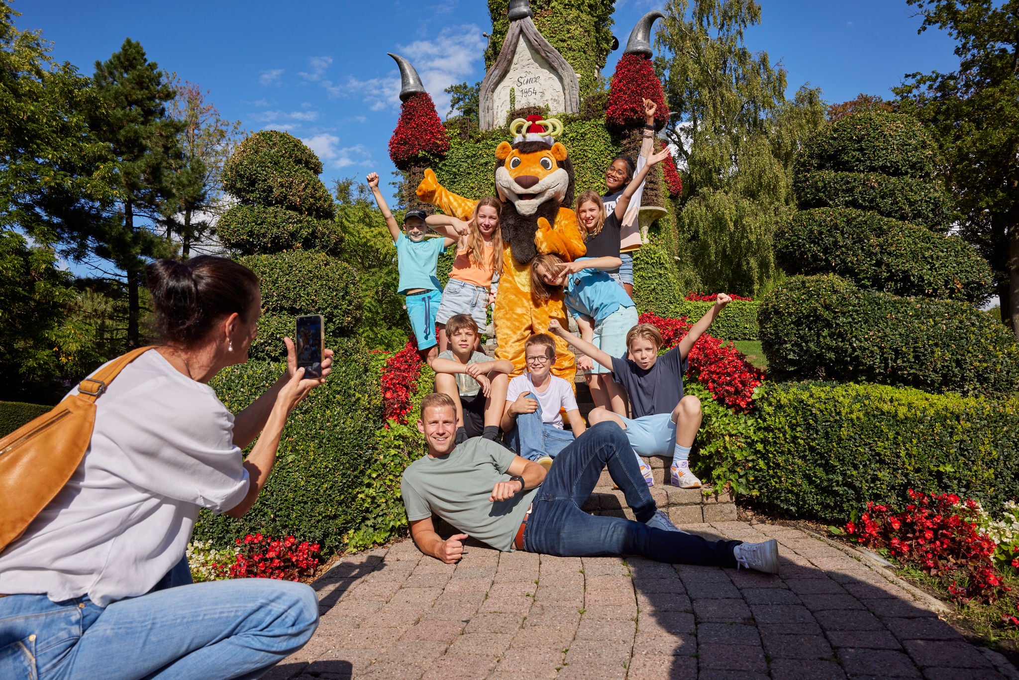 Fotomoment met Koning Leeuw, leerlingen en leerkracht bij het bloemenkasteel.